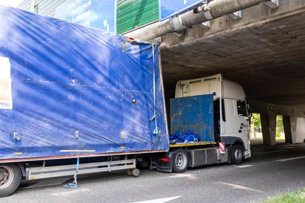 Vrachtwagen rijdt zich klem: viaduct en vrachtwagen beschadigd