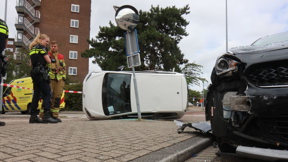 Auto op zijn kant na botsing met een taxi op de Van Deventerstraat in Schiedam