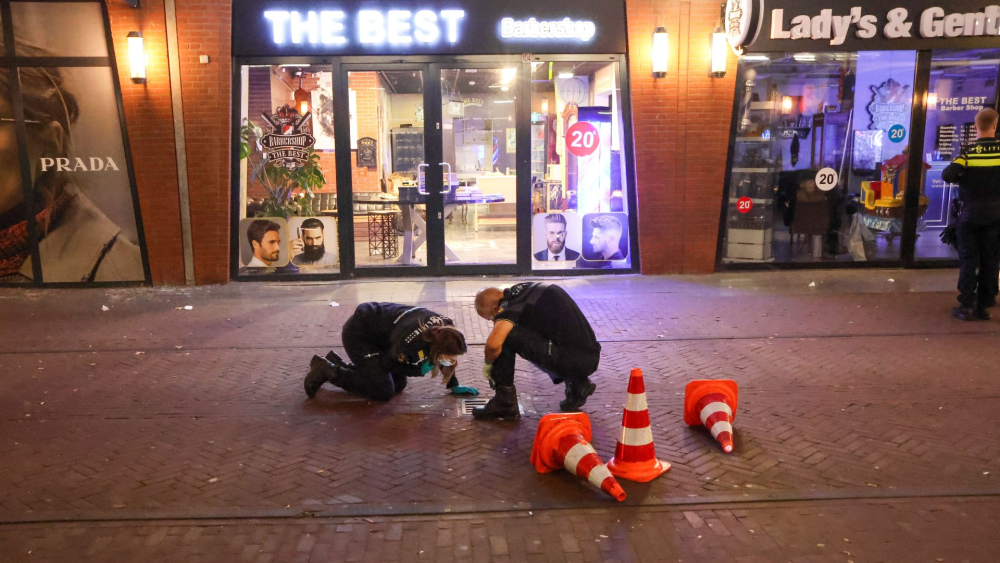 Politie onderzoekt de omgeving na het schietincident bij de kapperszaak onder het Liesveldviaduct op 16 oktober 2026