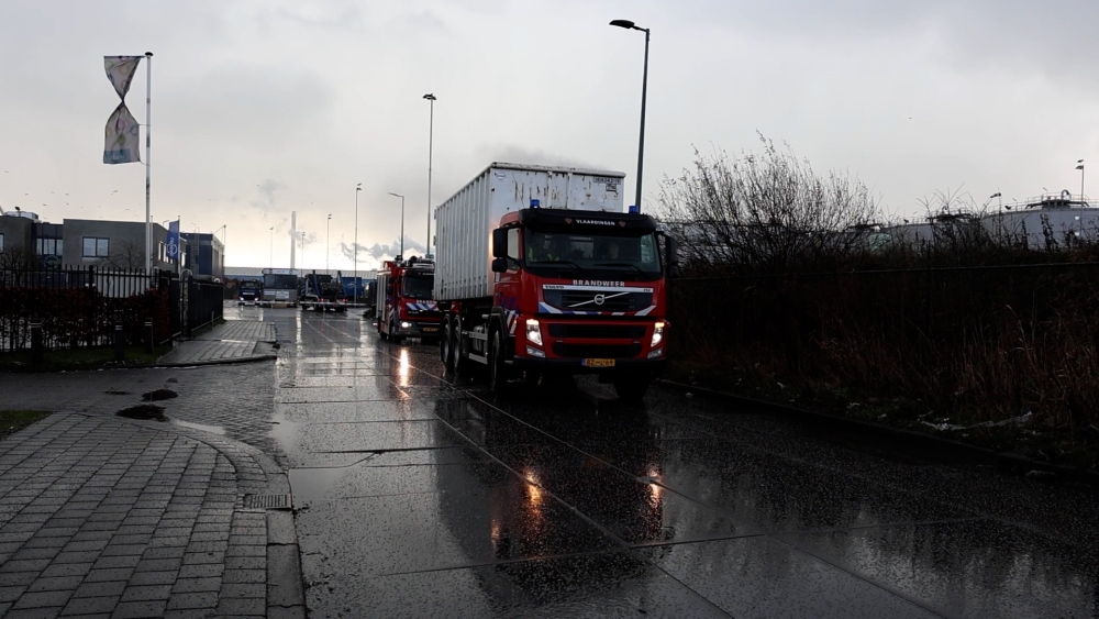 Brandweer rijdt met brandende container over openbare weg