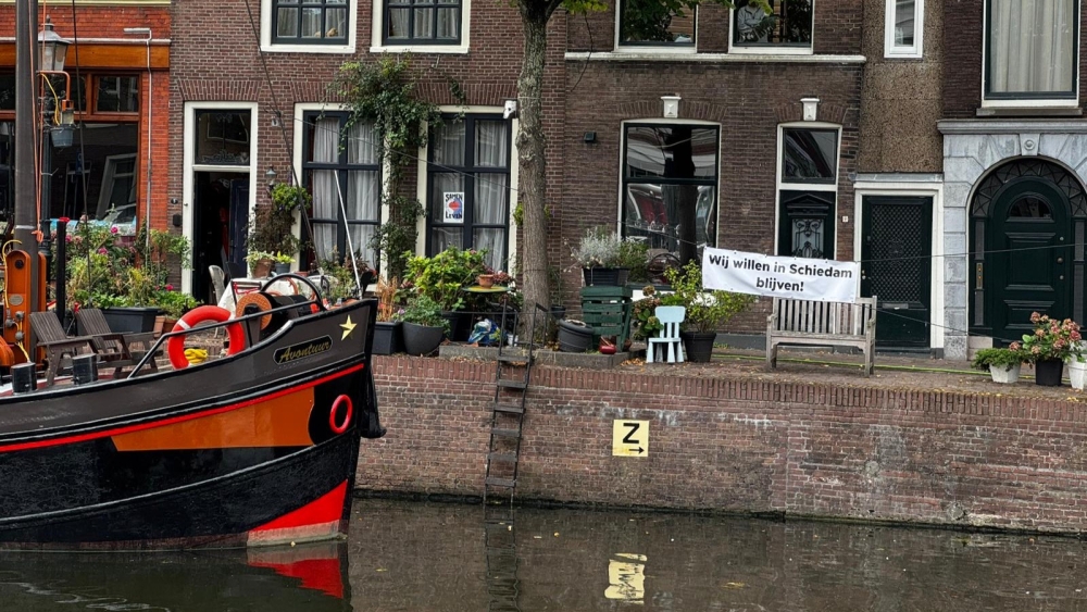 Het schip van Jan en Anna, met daarnaast het spandoek uit protest
