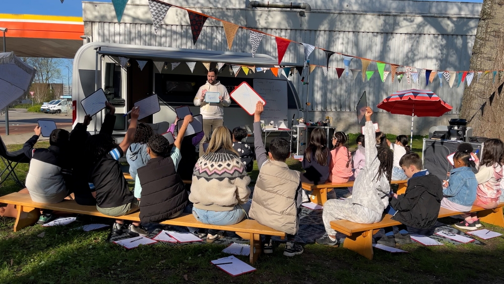 Leraar van basisschool De Loep geeft groep 4 les op een camping naast de school