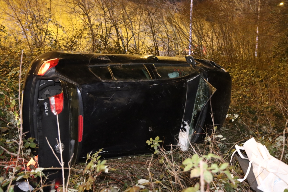 Auto schiet uit de bocht van snelweg, rijdt door bosjes en belandt op z'n zijkant