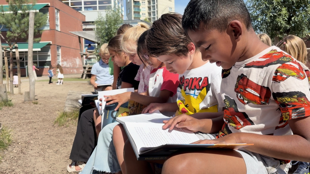 Plein basisschool De Vlinder vol lezende kinderen dankzij boek over Schiedam