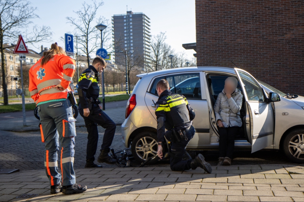 Na de aanrijding zit de fiets vast onder de auto