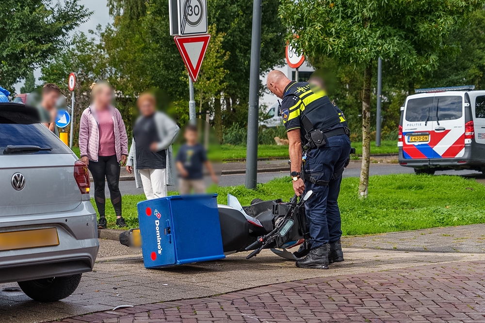 Bezorgscooter en auto botsen op elkaar, bezorger gewond